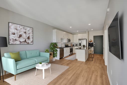 a living room with a couch a table and a kitchen in the background