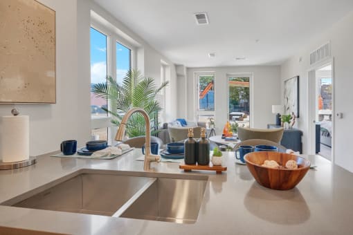 a kitchen counter with a sink and a view of a living room