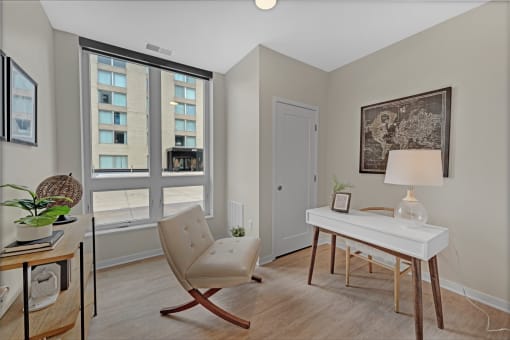 a bedroom with a desk and a chair and a window