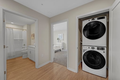 a washer and dryer in a living room with a bathroom and a bedroom