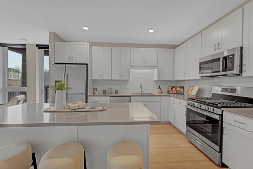 a kitchen with white cabinets and stainless steel appliances