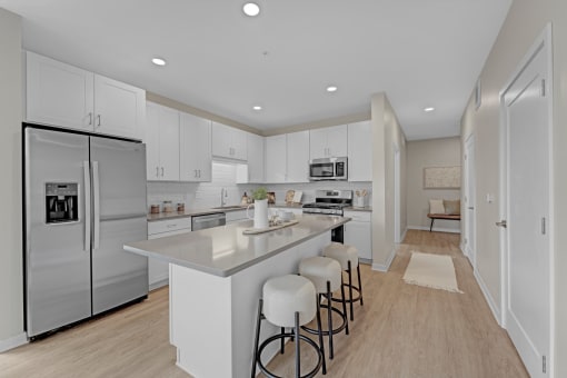 a large kitchen with white cabinets and stainless steel appliances