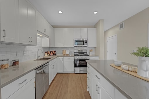 a large kitchen with white cabinets and stainless steel appliances