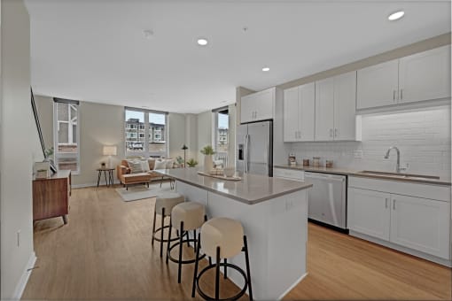 an open kitchen and living room with an island and stools