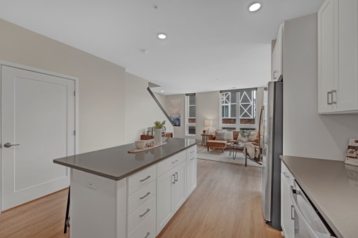 a kitchen with white cabinets and a counter top and a refrigerator