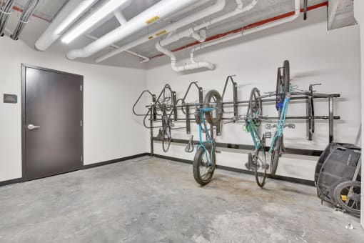 the interior of a garage with bikes hanging on the wall and a black door
