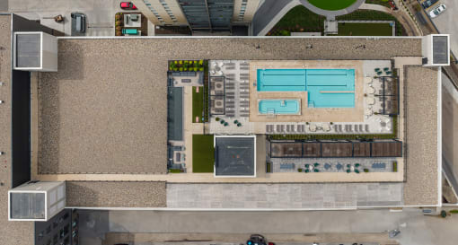 a rooftop view of a building with a pool and a parking lot