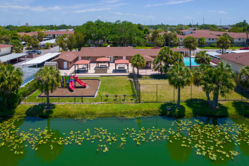 an aerial view of a park with a playground and a pond