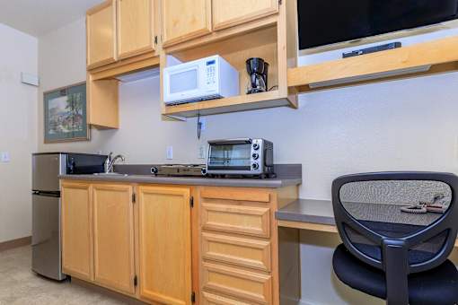 A Kitchen With Wooden Cabinets at Atrium Garden Apartment Homes, LLC, California