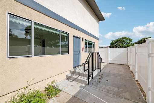 White fence around the building at Ocean Villas Apartments, Oxnard
