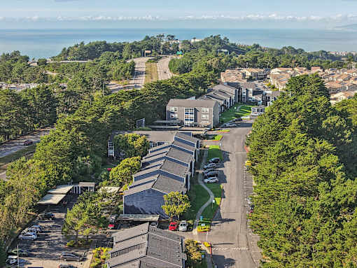 A bird's eye view of a residential area with houses and trees. at Skyline Heights Apartments, California, 94015