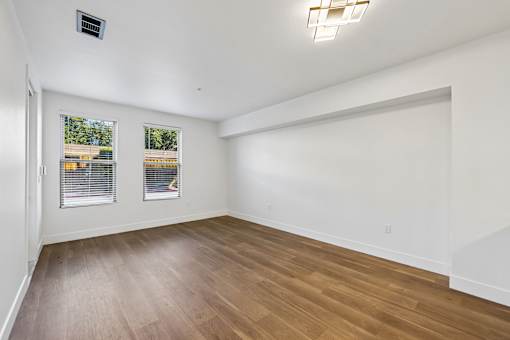 A room with wooden flooring and white walls.