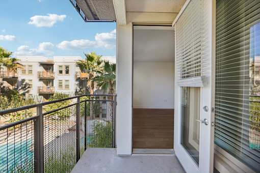A balcony with a pool and a building in the background.