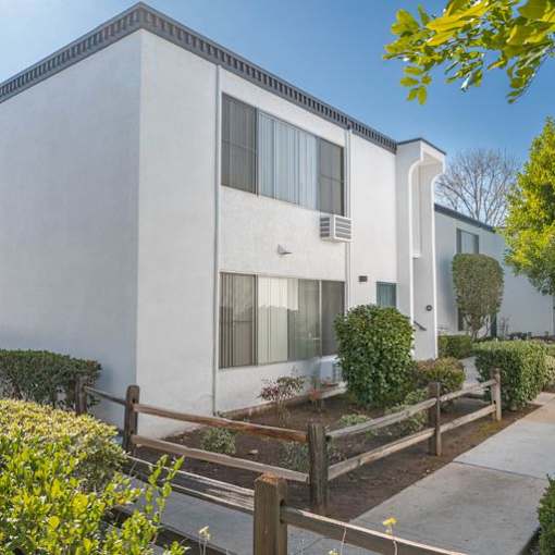 a white house with a yard in front of it at The Arches Apartments, El Cajon, CA