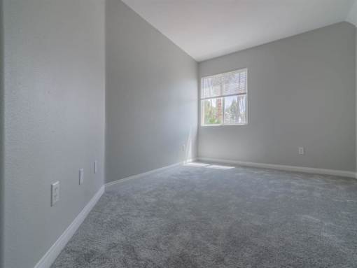 an empty living room with a window and carpet at Warner Center Townhomes, Canoga Park, CA