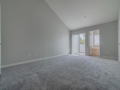 an empty living room with white walls and a door at Warner Center Townhomes, Canoga Park, CA