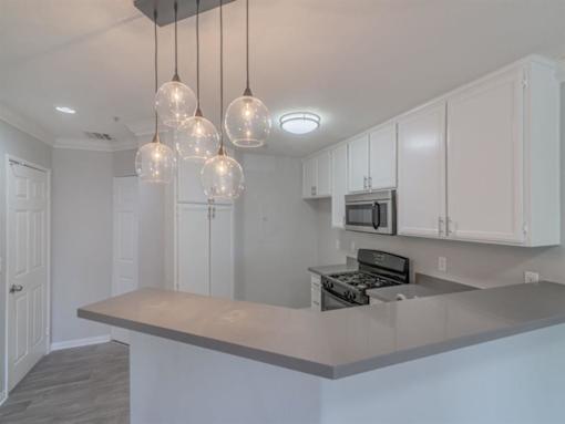 a kitchen with white cabinets and a counter top at Warner Center Townhomes, Canoga Park, CA 91303