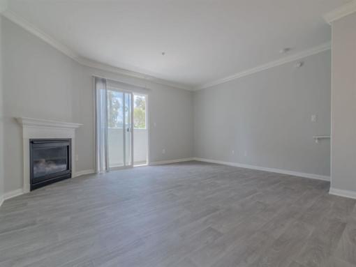 an empty living room with a fireplace and a sliding glass door at Warner Center Townhomes, Canoga Park, 91303