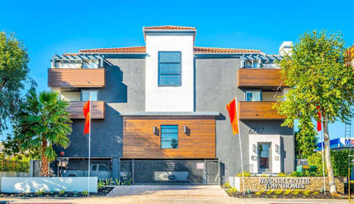 a house with two orange flags in front of it at Warner Center Townhomes, Canoga Park
