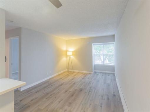 an empty living room with wood floors and a window at Skyline Heights Apartments, California