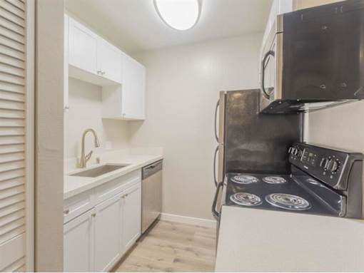 a kitchen with a stove and a sink and a microwave at Skyline Heights Apartments, Daly City, 94015