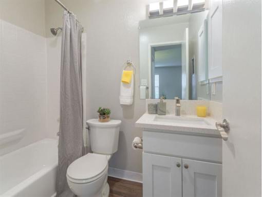 a bathroom with a sink toilet and a mirror at Skyline Heights Apartments, Daly City, California