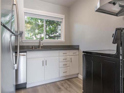 a kitchen with white cabinets and a window at The Pier at Sausalito, Sausalito, CA