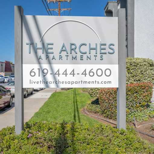 a sign for the arches apartments on the side of a street at The Arches Apartments, El Cajon, CA