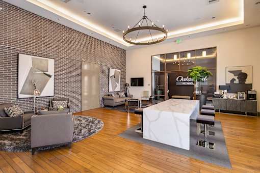 A modern living room with a white marble coffee table and a chandelier hanging from the ceiling. at Cirrus Redwood City Apartments, Redwood City, 94061