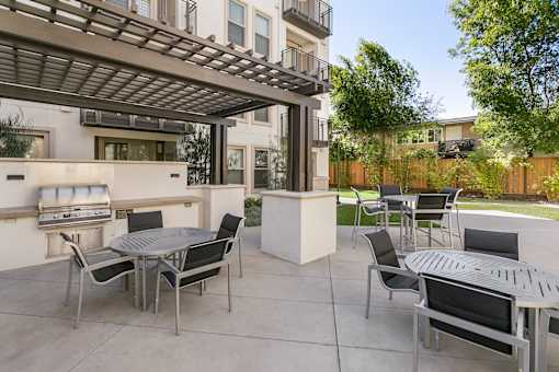A patio with a table and chairs under a pergola. at Cirrus Redwood City Apartments, Redwood City, CA, 94061