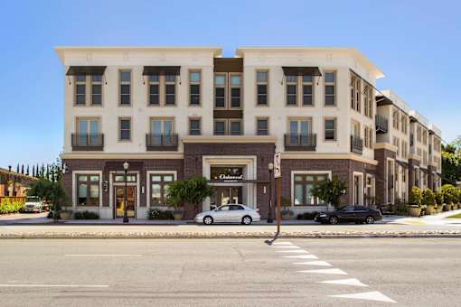 A street view of a building with cars parked in front. at Cirrus Redwood City Apartments, Redwood City, California