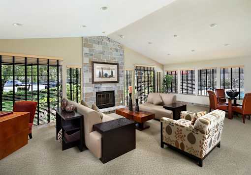 A living room with a fireplace and a painting on the wall. at The Maddox Sunnyvale Apartments, Sunnyvale, CA, 94087