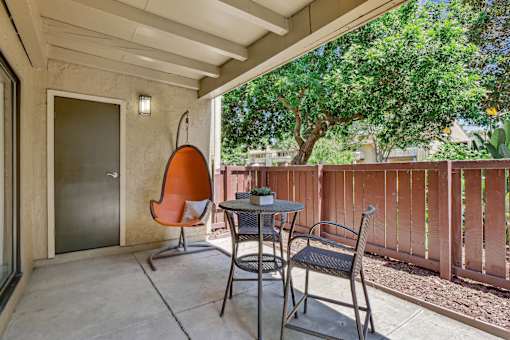 a patio with two chairs and a table and a door at Summerwood Apartments, Santa Clara