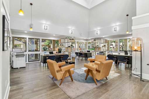 a living room with chairs and tables and a library at Summerwood Apartments, Santa Clara, CA