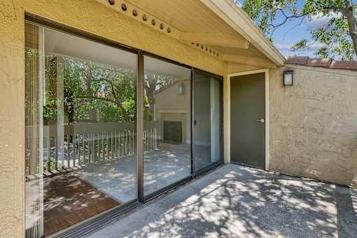 a patio with a glass door and a balcony at Summerwood Apartments, Santa Clara, 95050