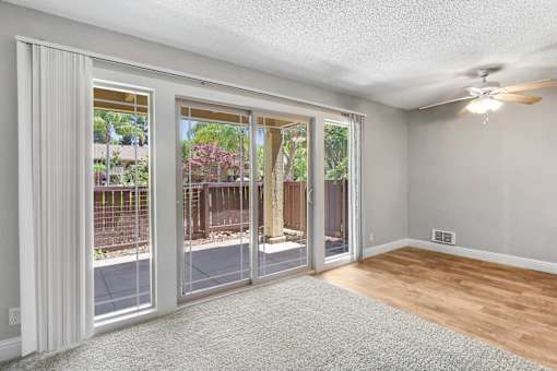 an empty living room with sliding glass doors to a patio at Summerwood Apartments, Santa Clara, 95050