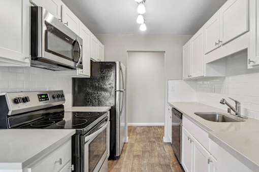 kitchen with white cabinets and stainless steel appliances at Summerwood Apartments, California