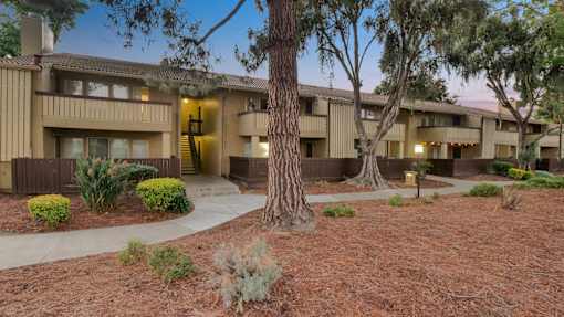 an apartment building with a courtyard and trees in front of it at Summerwood Apartments, California