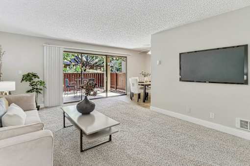 a living room with a tv and a sliding glass door at Summerwood Apartments, Santa Clara, 95050