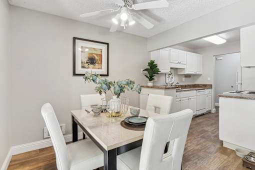 a dining room and kitchen with white cabinets and a table and chairs at Summerwood Apartments, California, 95050
