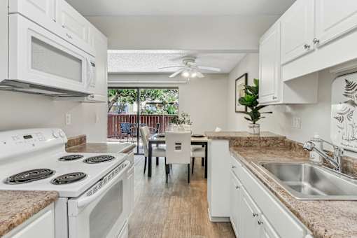 a kitchen with white appliances and granite counter tops at Summerwood Apartments, California