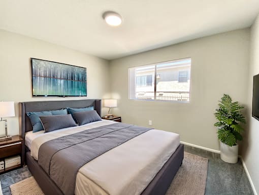 A bedroom with a large bed and a painting on the wall.