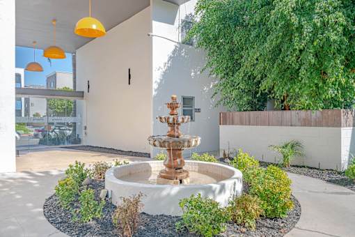 a fountain in a courtyard in front of a building at The Flats on Addison, Sherman Oaks