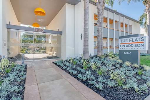 the flats on adelaide building entrance with palm trees at The Flats on Addison, Sherman Oaks, 91423