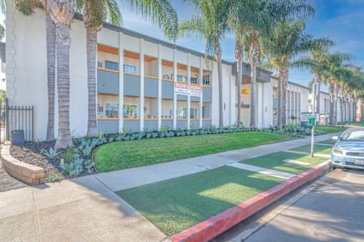 the front of a building with palm trees in front of it at The Flats on Addison, California