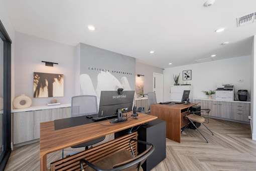 A modern office space with a wooden desk and chairs at Latitude Apartments at Mission Valley Apartments, San Diego, CA, 92120