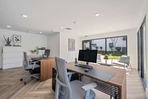 A modern office with a wooden desk and a computer monitor at Latitude Apartments at Mission Valley Apartments, San Diego, California