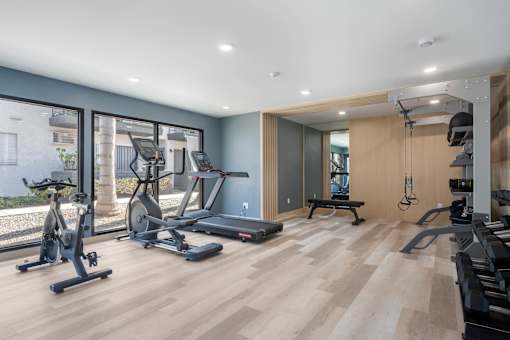 A spacious home gym with a variety of exercise equipment at Latitude Apartments at Mission Valley Apartments, California, 92120
