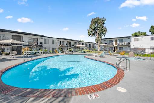 A swimming pool with a red brick border and a sign that says 6. at Latitude Apartments at Mission Valley Apartments, San Diego, CA