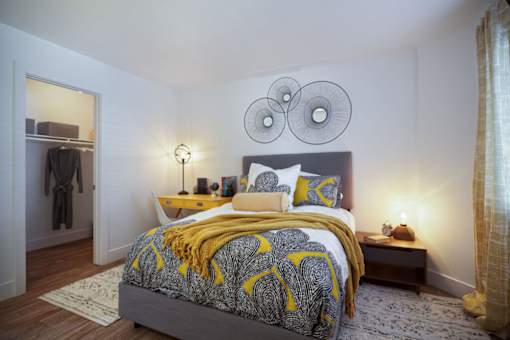 a bedroom with a bed and two mirrors on the wallat The Bryant, California, 92887